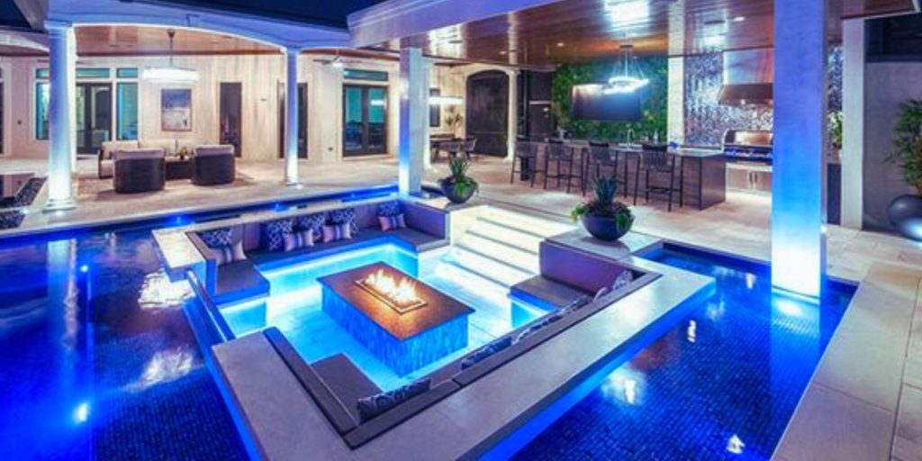 The pool is surrounded by furniture 