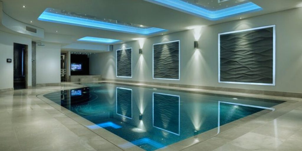 A large room with an enclosed Indoor pool and a large glass wall.