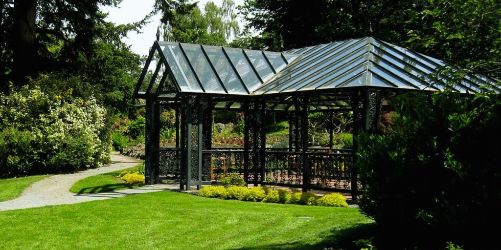 A gazebo in a park surrounded by trees and grass