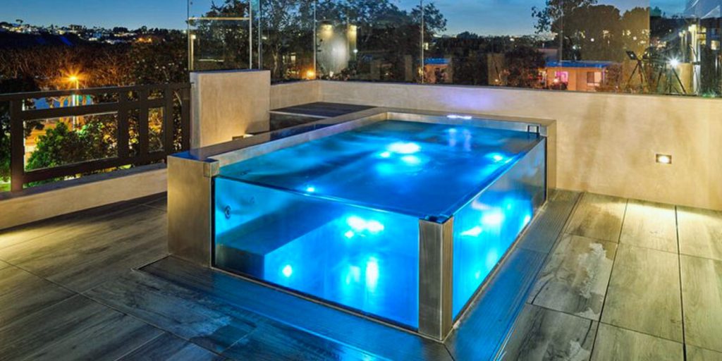 A swimming pool illuminated with lights at night.