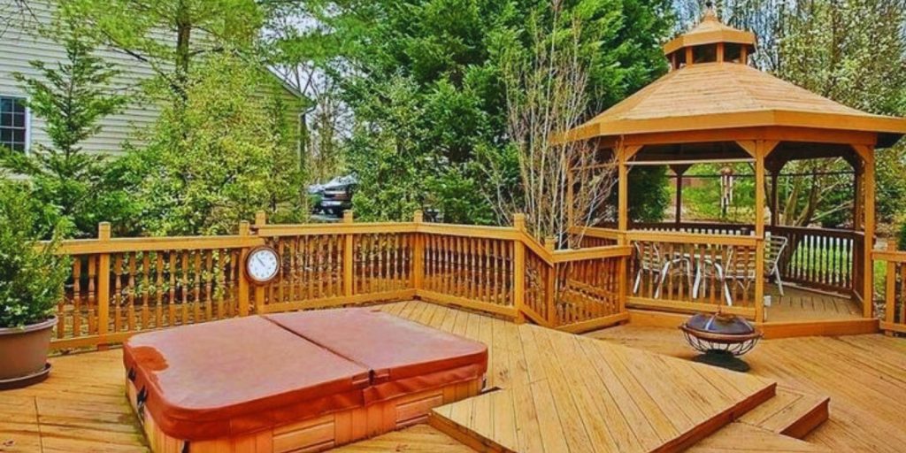 wooden gazebo surrounded by outdoor furniture like tables and chairs