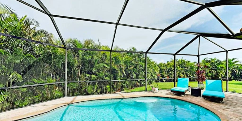 Pool with chairs around it in an outdoor setting.