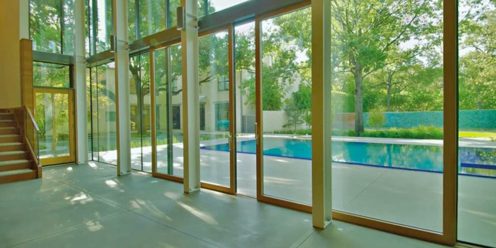 A swimming pool with tempered glass doors, set in an indoor space.