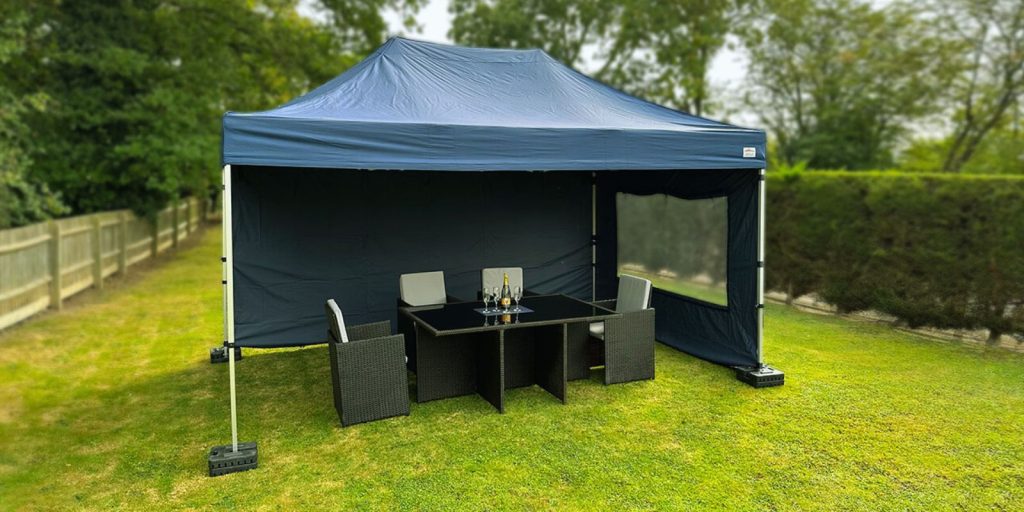 A temporary gazebo with a table and chair nearby.