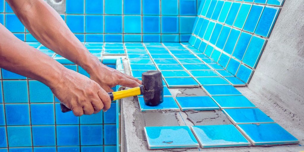 A person using a tool to cut a tile