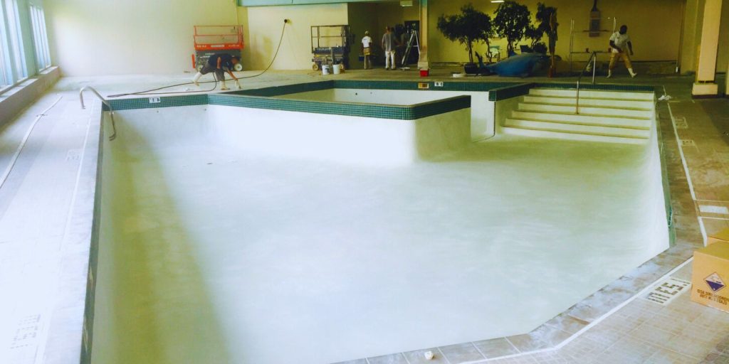  A large indoor swimming pool with composite material flooring and tiled walls.