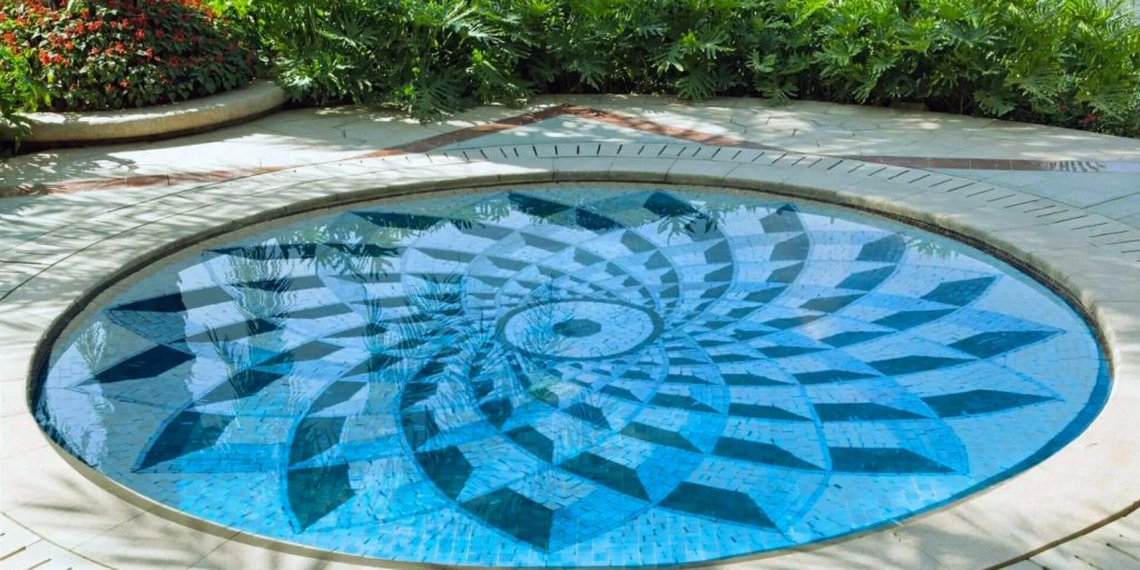 An outdoor pool with a blue tile surface in a garden setting