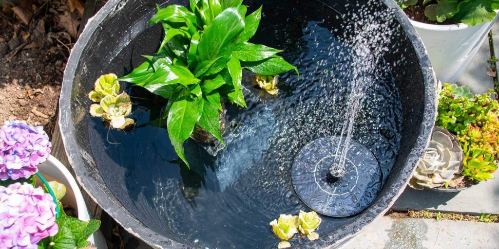 A fountain with water and flowers.