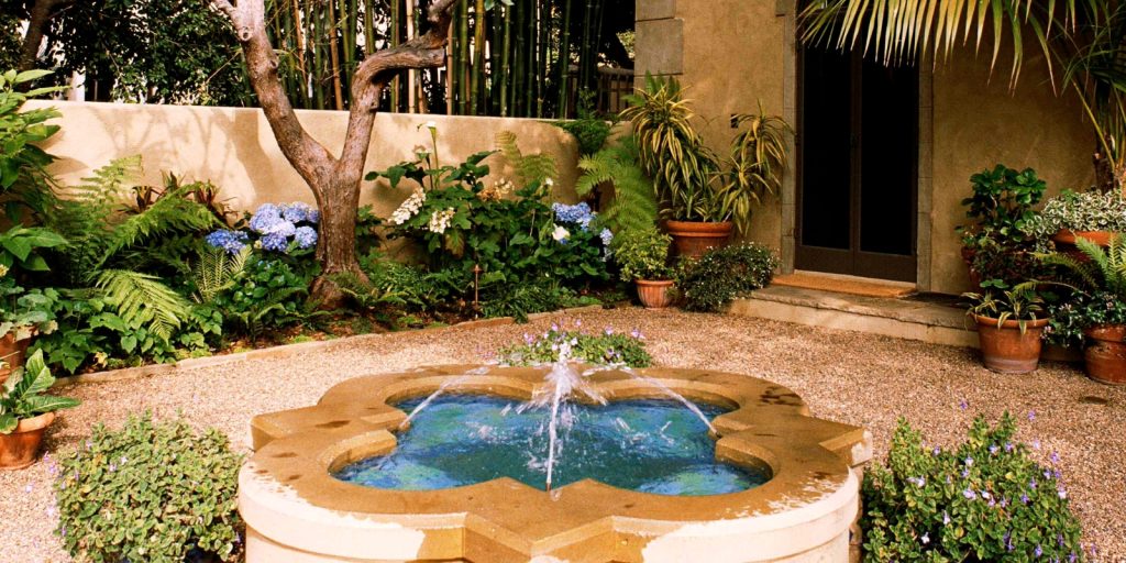  A pool in a backyard, surrounded by houseplants and flowerpots.