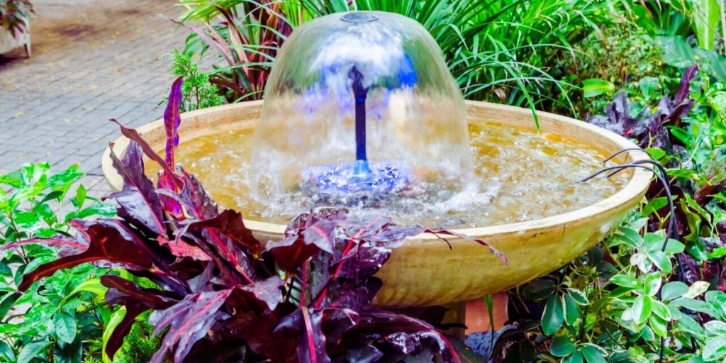 A fountain filled with water in a garden setting. 